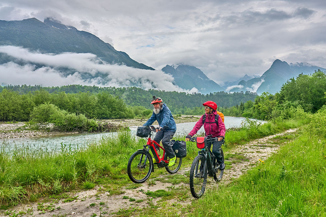 Older people bicycling in scenic nature. 